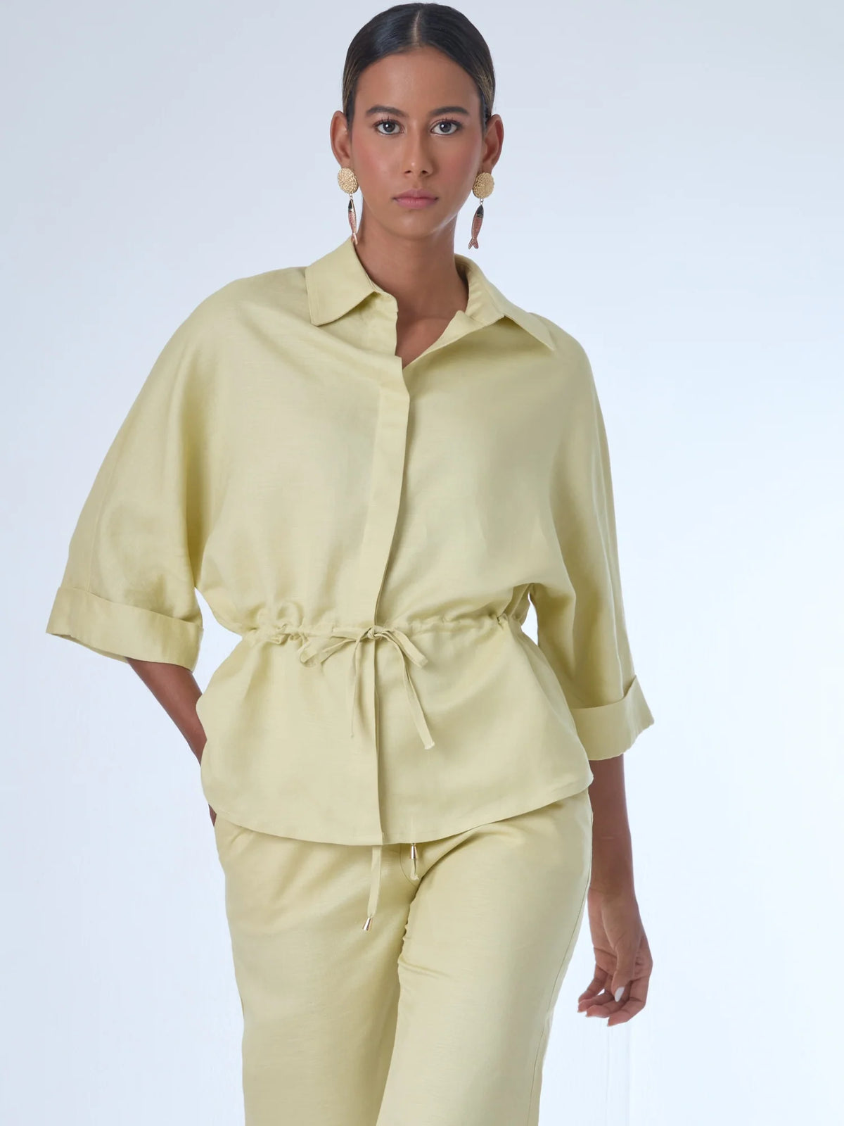 Blusa sin mangas de corte recto y silueta relajada. Tiene cuello redondo cerrado y un diseño limpio sin detalles visibles, lo que le da un estilo minimalista y moderno. El largo llega justo a la cintura, ideal para llevar por fuera o combinada con prendas de talle alto para un look fresco y sofisticado