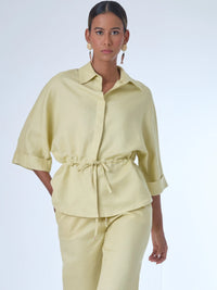 Blusa sin mangas de corte recto y silueta relajada. Tiene cuello redondo cerrado y un diseño limpio sin detalles visibles, lo que le da un estilo minimalista y moderno. El largo llega justo a la cintura, ideal para llevar por fuera o combinada con prendas de talle alto para un look fresco y sofisticado