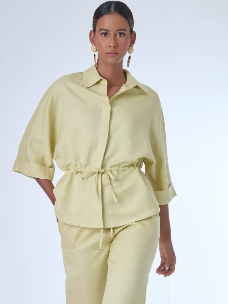 Blusa sin mangas de corte recto y silueta relajada. Tiene cuello redondo cerrado y un diseño limpio sin detalles visibles, lo que le da un estilo minimalista y moderno. El largo llega justo a la cintura, ideal para llevar por fuera o combinada con prendas de talle alto para un look fresco y sofisticado