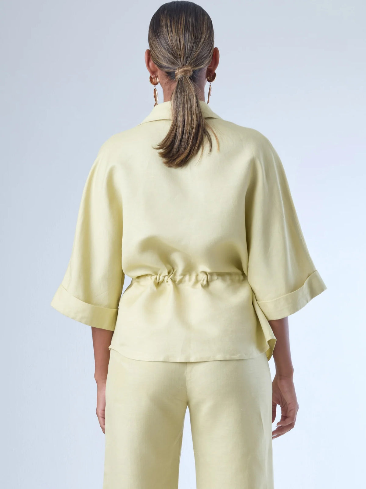 Blusa sin mangas de corte recto y silueta relajada. Tiene cuello redondo cerrado y un diseño limpio sin detalles visibles, lo que le da un estilo minimalista y moderno. El largo llega justo a la cintura, ideal para llevar por fuera o combinada con prendas de talle alto para un look fresco y sofisticado