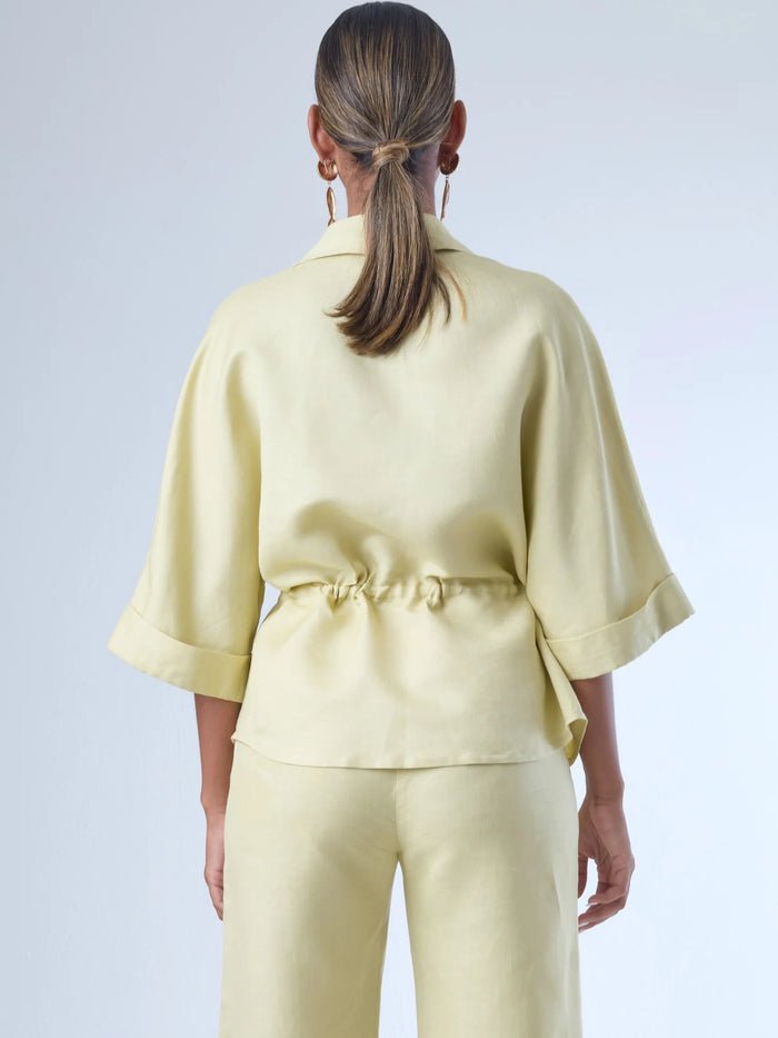 Blusa sin mangas de corte recto y silueta relajada. Tiene cuello redondo cerrado y un diseño limpio sin detalles visibles, lo que le da un estilo minimalista y moderno. El largo llega justo a la cintura, ideal para llevar por fuera o combinada con prendas de talle alto para un look fresco y sofisticado
