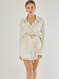 Blusa tipo camisera de manga larga con sutiles rayas y cinturón trenzado que define la figura. Su diseño ligero y relajado ofrece un estilo casual con toques elegantes, ideal para llevar con faldas o pantalones en looks versátiles y modernos.

Detalles:

Color: Blanco

Material: 77% Rayon 23% Nylon

Características: Incluye cinturón a tono.