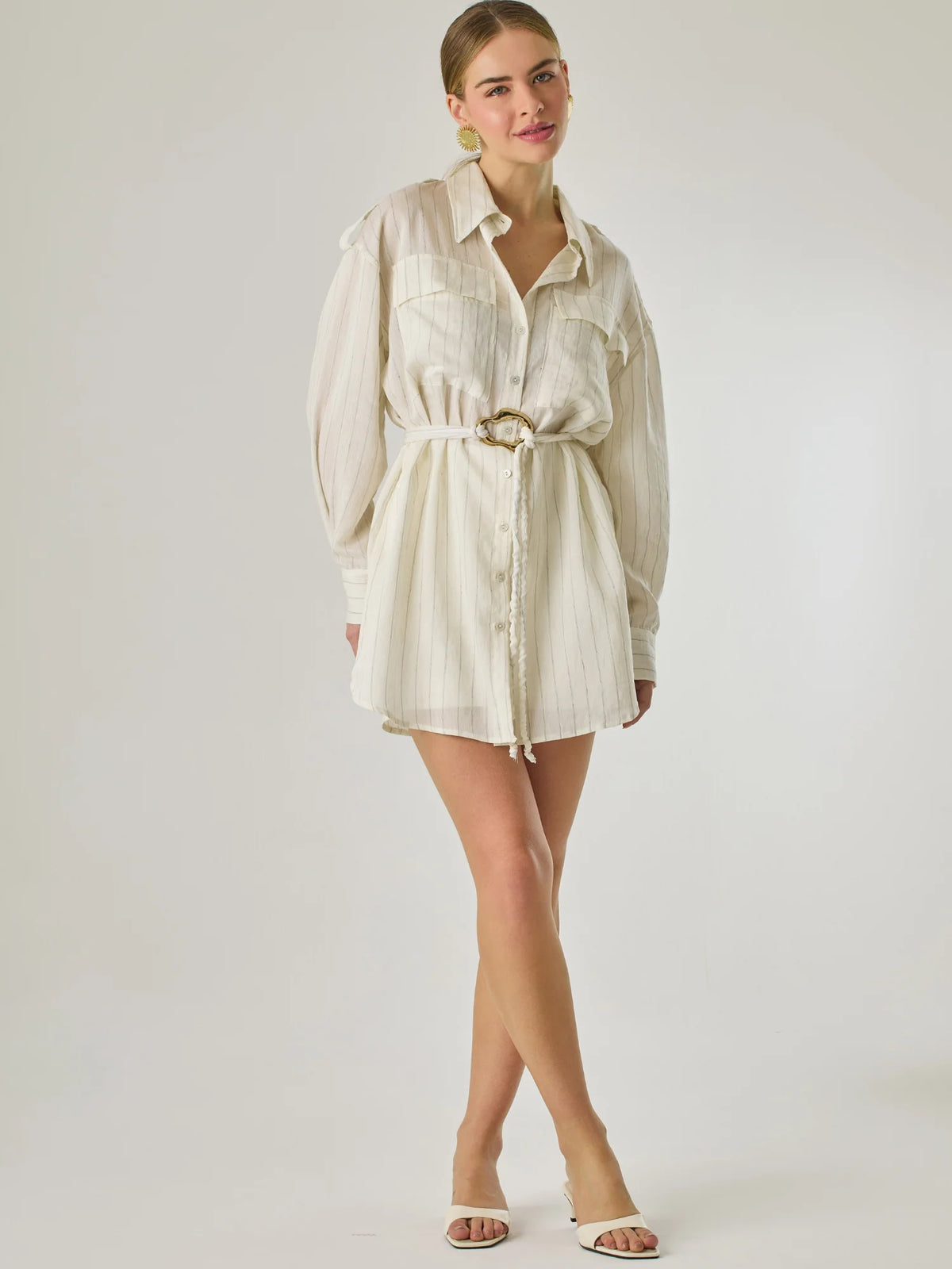 Blusa tipo camisera de manga larga con sutiles rayas y cinturón trenzado que define la figura. Su diseño ligero y relajado ofrece un estilo casual con toques elegantes, ideal para llevar con faldas o pantalones en looks versátiles y modernos.

Detalles:

Color: Blanco

Material: 77% Rayon 23% Nylon

Características: Incluye cinturón a tono.