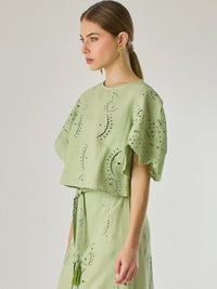 Blusa de silueta recta con delicados bordados en todo el tejido. Sus mangas cortas de acabado ondulado aportan un aire femenino y romántico. El diseño incluye detalles calados que aportan textura y ligereza, convirtiéndola en una prenda ideal para looks frescos y sofisticados.

Detalles:

Color: Verde

Material: 70% Rayón 30% Lino
