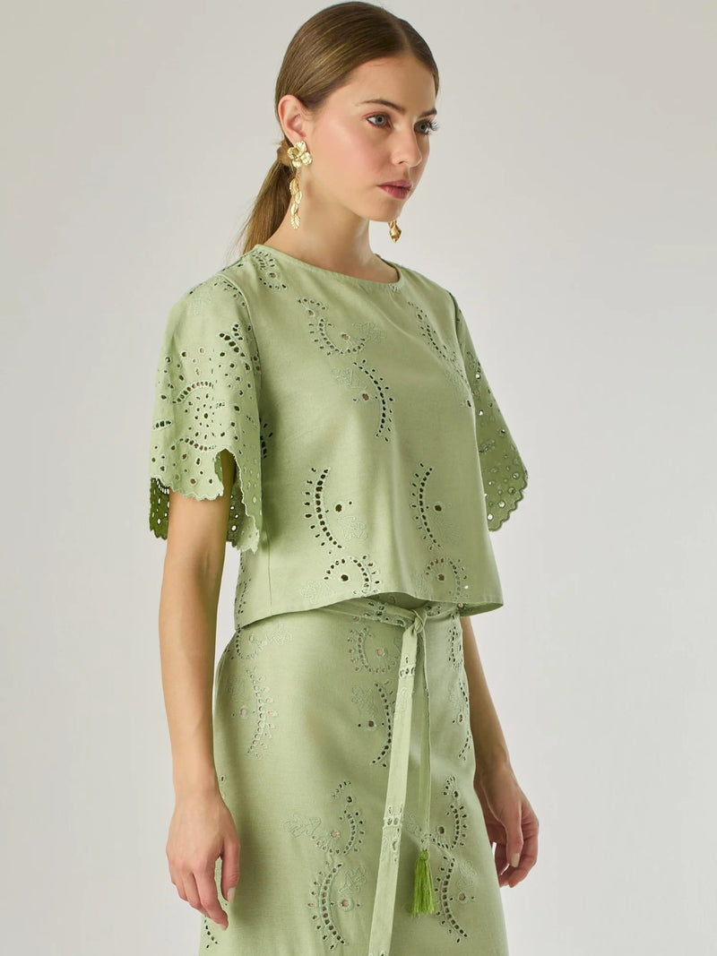 Blusa de silueta recta con delicados bordados en todo el tejido. Sus mangas cortas de acabado ondulado aportan un aire femenino y romántico. El diseño incluye detalles calados que aportan textura y ligereza, convirtiéndola en una prenda ideal para looks frescos y sofisticados.

Detalles:

Color: Verde

Material: 70% Rayón 30% Lino