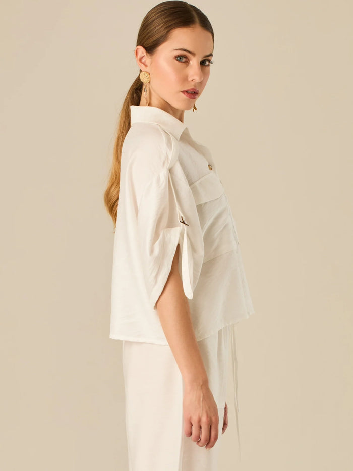 Blusa de silueta relajada con botones al frente, bolsillos tipo parche y mangas con detalle de amarre que aporta un aire desenfadado y chic. Su estilo versátil la convierte en una opción perfecta para looks casuales con un toque sofisticado.

Detalles:

Color: Blanco