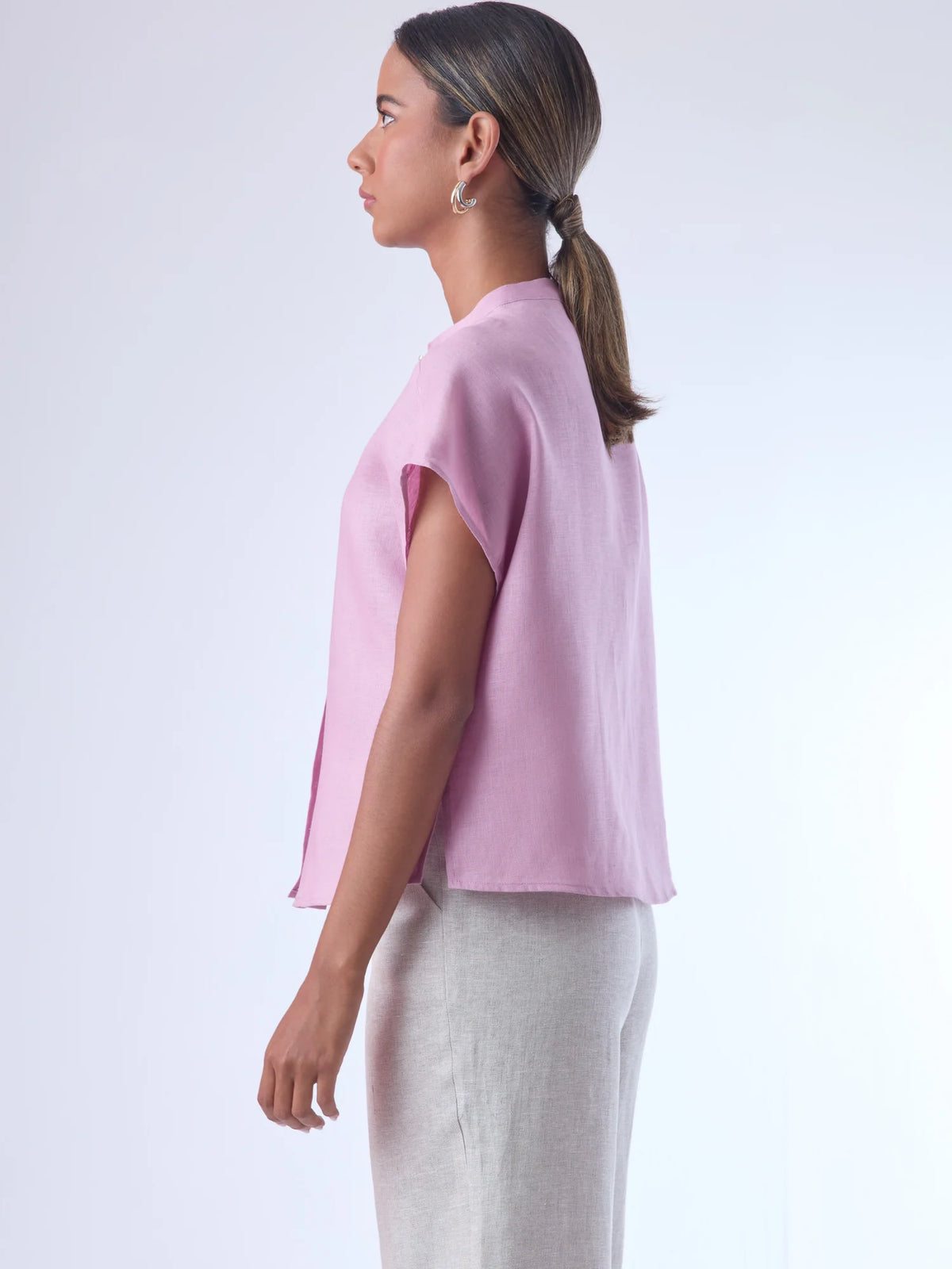 Blusa de silueta recta con manga corta tipo caída y estructura relajada. Cuenta con cuello que se cierra con un pequeño broche metálico decorativos estilo sobrio la hace versátil y elegante, ideal para atuendos casuales o más refinados.