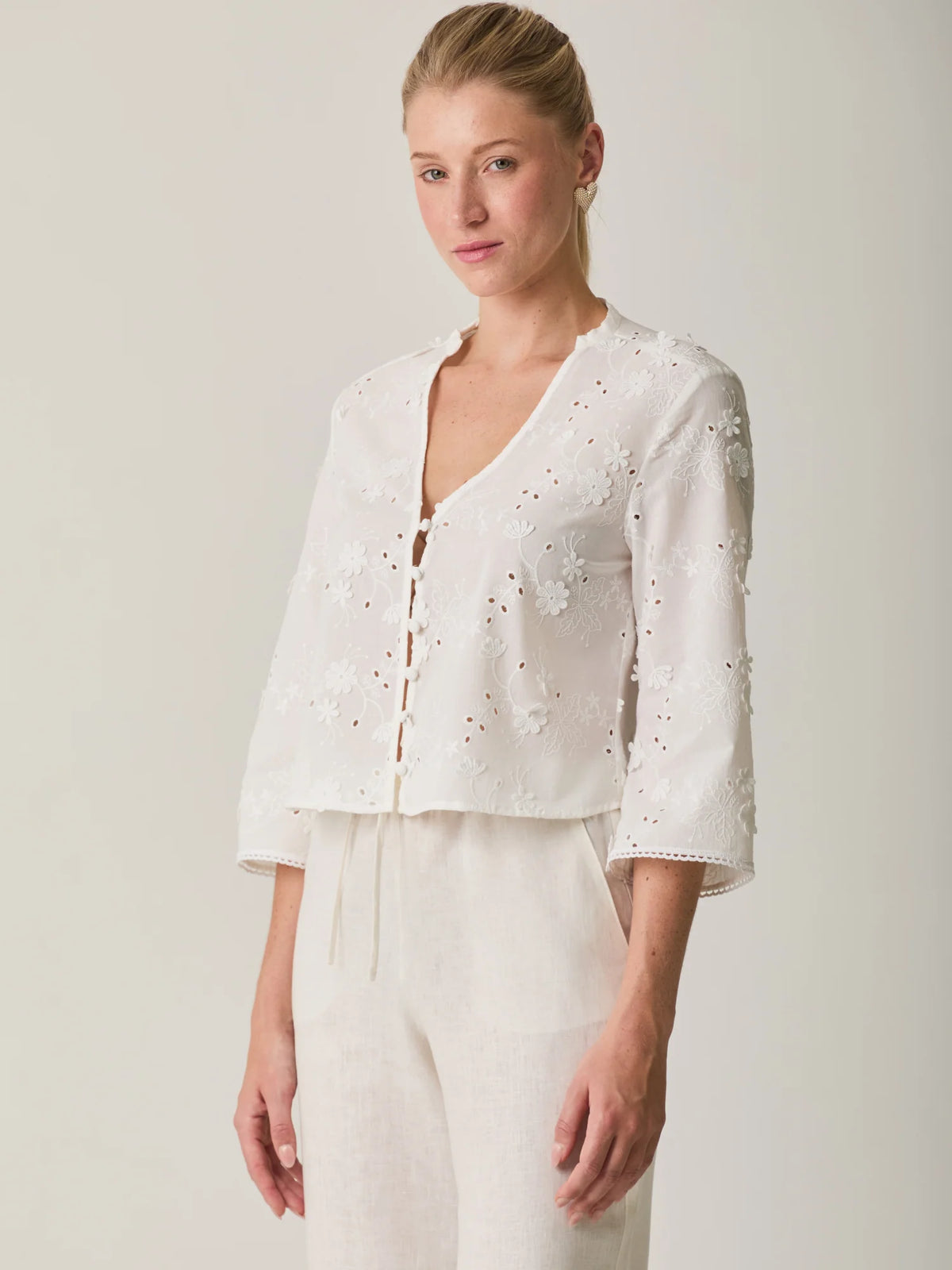 Blusa Maddie Blanco delicada con manga 3/4, diseño floral bordado y textura ligera.