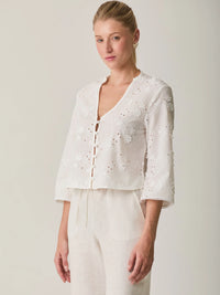 Blusa Maddie Blanco delicada con manga 3/4, diseño floral bordado y textura ligera.