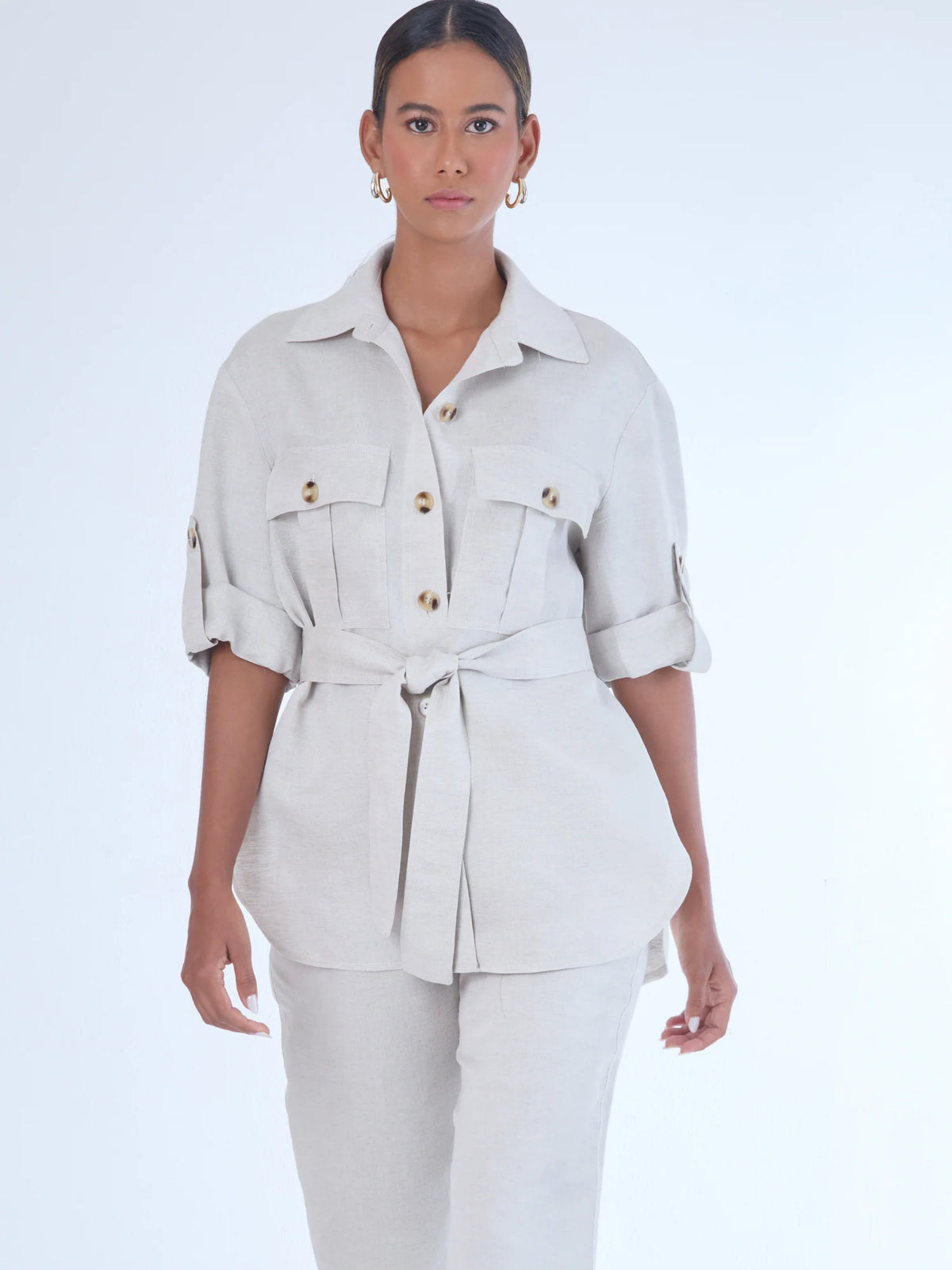 Estructurada y versátil, esta sobrecamisa de corte recto incorpora un cinturón que define la cintura y realza la silueta. Con bolsillos tipo parche en el pecho, manga con ajuste y botonadura clásica, es una prenda ideal para looks monocromáticos, estilismos urbanos o conjuntos sofisticados de inspiración utilitaria. Perfecta como pieza central de un outfit cómodo y elegante.