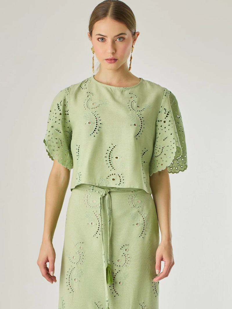 Blusa de silueta recta con delicados bordados en todo el tejido. Sus mangas cortas de acabado ondulado aportan un aire femenino y romántico. El diseño incluye detalles calados que aportan textura y ligereza, convirtiéndola en una prenda ideal para looks frescos y sofisticados.

Detalles:

Color: Verde

Material: 70% Rayón 30% Lino