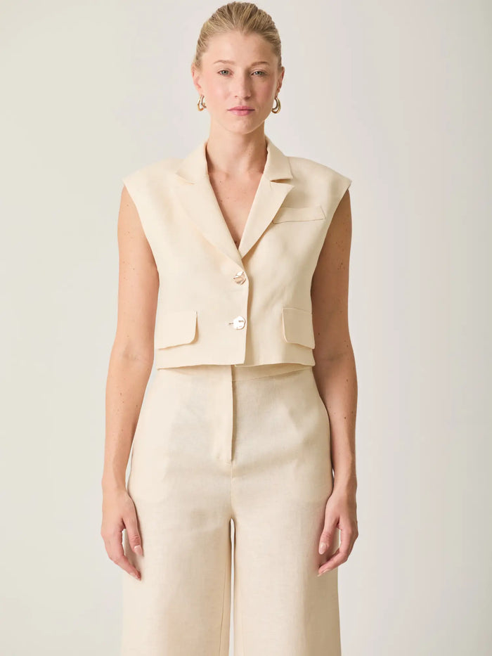 Blusa Rebe Crema corta con botones dorados y estilo moderno ideal para looks sofisticados.