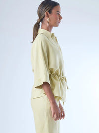 Blusa sin mangas de corte recto y silueta relajada. Tiene cuello redondo cerrado y un diseño limpio sin detalles visibles, lo que le da un estilo minimalista y moderno. El largo llega justo a la cintura, ideal para llevar por fuera o combinada con prendas de talle alto para un look fresco y sofisticado