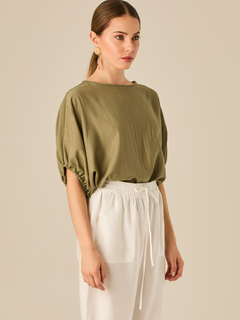 Blusa de caída ligera con detalle acanalado y mangas abullonadas ajustables. Su estilo relajado y delicado la convierte en una prenda versátil y sofisticada, perfecta para elevar looks cotidianos con elegancia sutil.

Detalles:

Color: Olivo