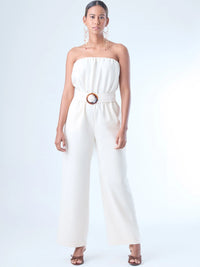 Jumpsuit sin tirantes de corte largo y silueta fluida. El diseño superior tiene un efecto fruncido en el escote elástico, que se ajusta suavemente al cuerpo. En la cintura destaca un cinturón ancho con hebilla redonda que define la figura. El pantalón cae recto hasta el tobillo con un estilo relajado y elegante. Ideal para un look moderno con aire minimalista.
