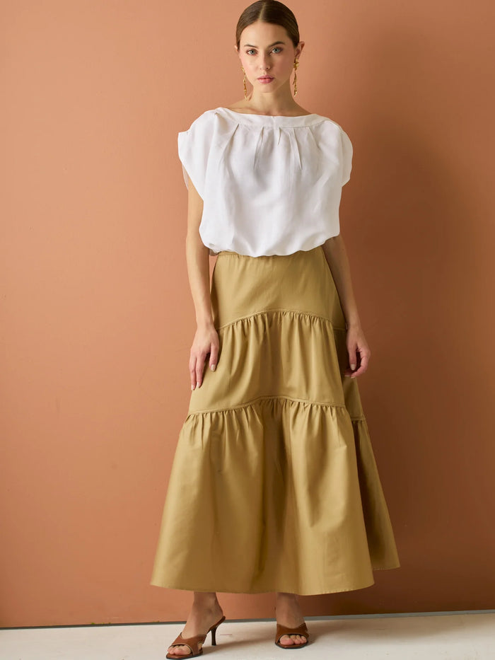 Falda larga con diseño&nbsp; de volantes suaves que aportan movimiento y volumen. Su silueta amplia y estructura liviana la hacen perfecta para un look relajado y sofisticado, ideal para combinar con blusas ligeras y crear estilismos con encanto natural.

Detalles:

Color: Camel