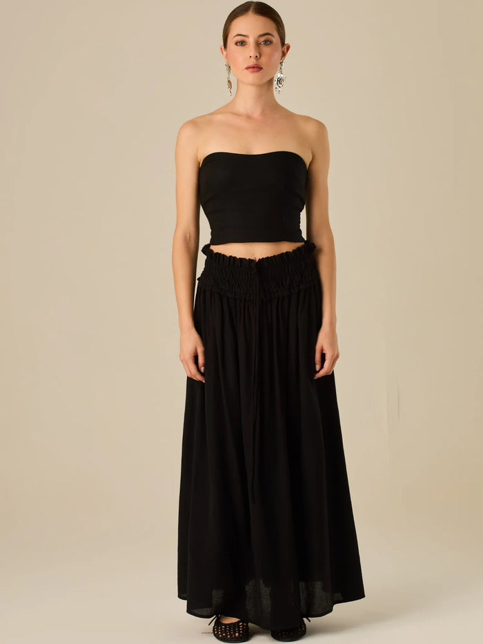 Falda larga de tiro alto con pretina fruncida y lazo ajustable, ideal para un look relajado con elegancia sutil. Su caída fluida y textura ligera aportan movimiento y frescura, perfecta para estilismos sofisticados con esencia natural.

Detalles:

Color: Negro

Material: 82% Rayon 18% Nylon