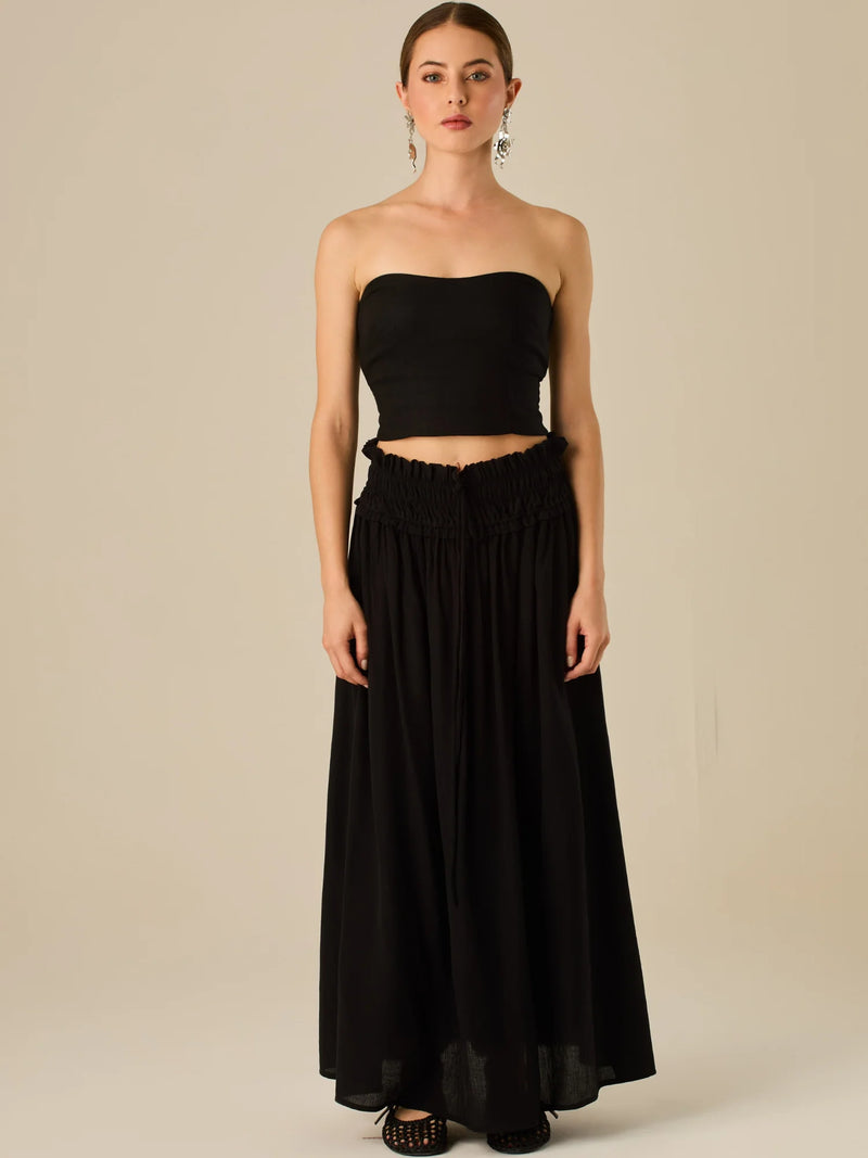 Falda larga de tiro alto con pretina fruncida y lazo ajustable, ideal para un look relajado con elegancia sutil. Su caída fluida y textura ligera aportan movimiento y frescura, perfecta para estilismos sofisticados con esencia natural.

Detalles:

Color: Negro

Material: 82% Rayon 18% Nylon