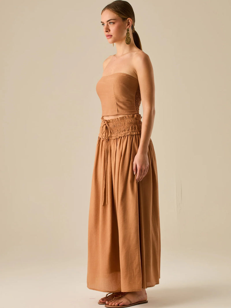 Falda larga de tiro alto con pretina fruncida y lazo ajustable, ideal para un look relajado con elegancia sutil. Su caída fluida y textura ligera aportan movimiento y frescura, perfecta para estilismos sofisticados con esencia natural.

Detalles:

Color: Camel

Material: 82% Rayon 18% Nylon