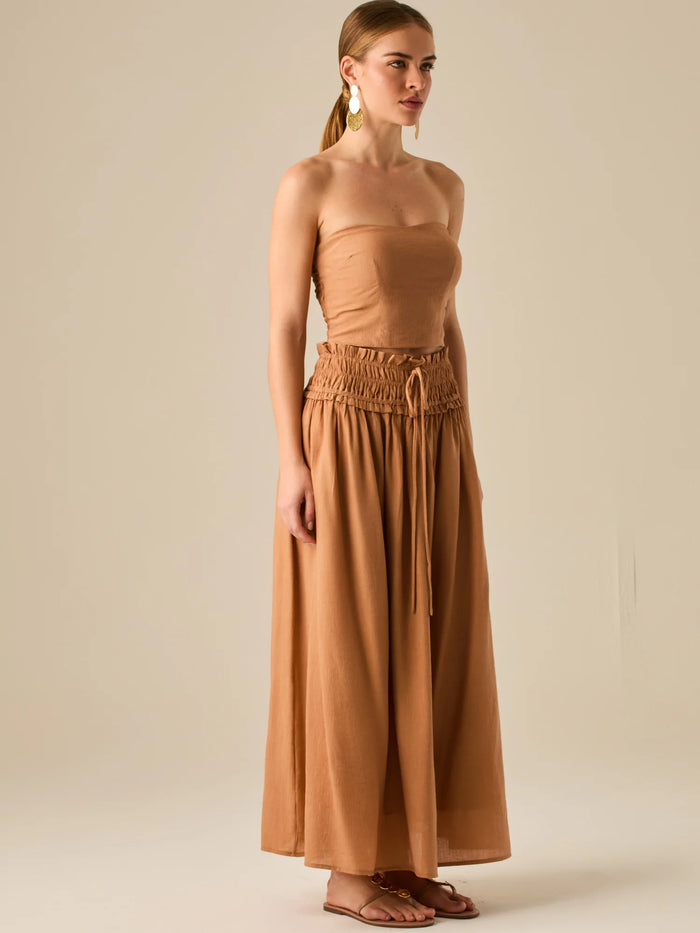Falda larga de tiro alto con pretina fruncida y lazo ajustable, ideal para un look relajado con elegancia sutil. Su caída fluida y textura ligera aportan movimiento y frescura, perfecta para estilismos sofisticados con esencia natural.

Detalles:

Color: Camel

Material: 82% Rayon 18% Nylon