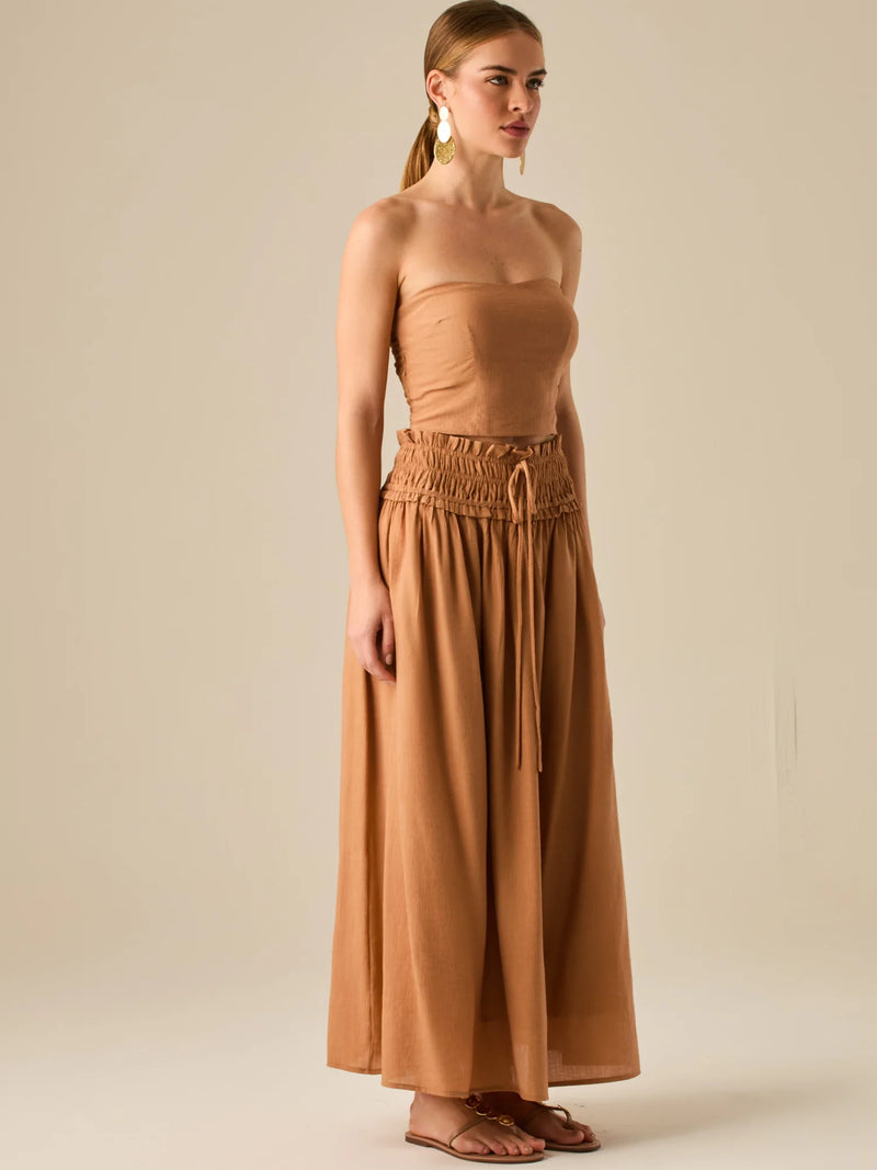 Falda larga de tiro alto con pretina fruncida y lazo ajustable, ideal para un look relajado con elegancia sutil. Su caída fluida y textura ligera aportan movimiento y frescura, perfecta para estilismos sofisticados con esencia natural.

Detalles:

Color: Camel

Material: 82% Rayon 18% Nylon