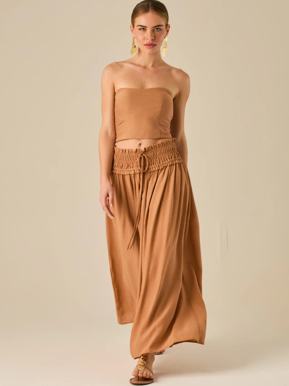 Falda larga de tiro alto con pretina fruncida y lazo ajustable, ideal para un look relajado con elegancia sutil. Su caída fluida y textura ligera aportan movimiento y frescura, perfecta para estilismos sofisticados con esencia natural.

Detalles:

Color: Camel

Material: 82% Rayon 18% Nylon
