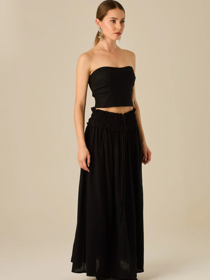 Falda larga de tiro alto con pretina fruncida y lazo ajustable, ideal para un look relajado con elegancia sutil. Su caída fluida y textura ligera aportan movimiento y frescura, perfecta para estilismos sofisticados con esencia natural.

Detalles:

Color: Negro

Material: 82% Rayon 18% Nylon