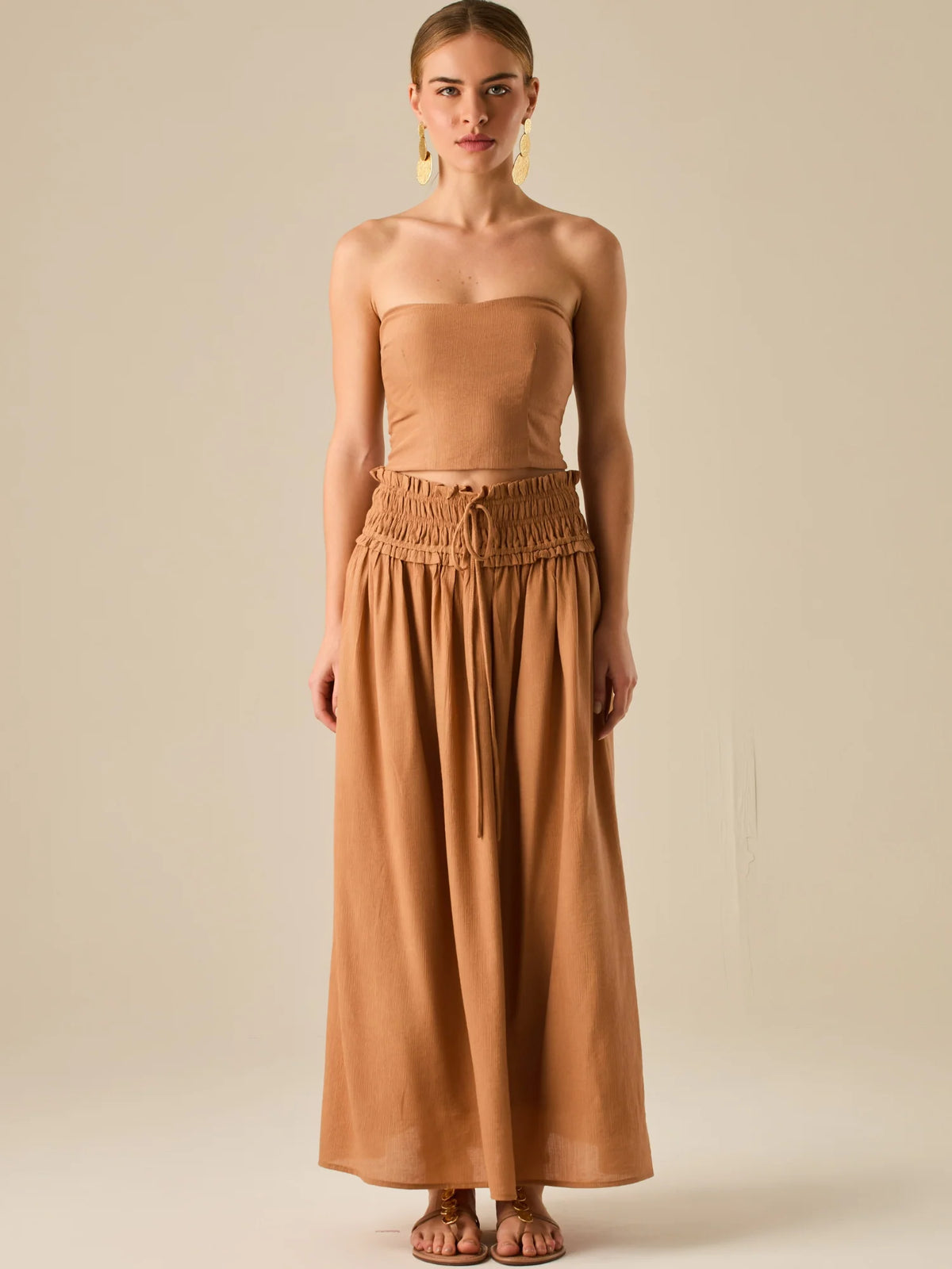 Falda larga de tiro alto con pretina fruncida y lazo ajustable, ideal para un look relajado con elegancia sutil. Su caída fluida y textura ligera aportan movimiento y frescura, perfecta para estilismos sofisticados con esencia natural.

Detalles:

Color: Camel

Material: 82% Rayon 18% Nylon