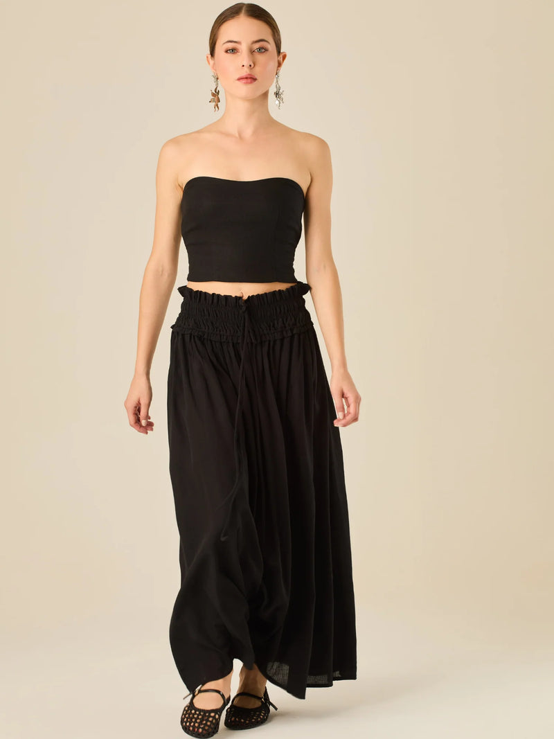 Falda larga de tiro alto con pretina fruncida y lazo ajustable, ideal para un look relajado con elegancia sutil. Su caída fluida y textura ligera aportan movimiento y frescura, perfecta para estilismos sofisticados con esencia natural.

Detalles:

Color: Negro

Material: 82% Rayon 18% Nylon