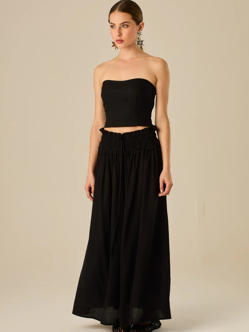 Falda larga de tiro alto con pretina fruncida y lazo ajustable, ideal para un look relajado con elegancia sutil. Su caída fluida y textura ligera aportan movimiento y frescura, perfecta para estilismos sofisticados con esencia natural.

Detalles:

Color: Negro

Material: 82% Rayon 18% Nylon