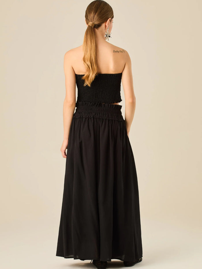 Falda larga de tiro alto con pretina fruncida y lazo ajustable, ideal para un look relajado con elegancia sutil. Su caída fluida y textura ligera aportan movimiento y frescura, perfecta para estilismos sofisticados con esencia natural.

Detalles:

Color: Negro

Material: 82% Rayon 18% Nylon