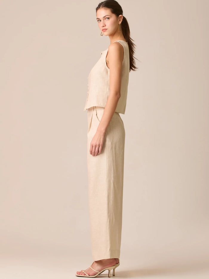 Pantalón de tiro medio con pretina plana, pinzas frontales y corte recto amplio hasta el tobillo, confeccionado en un tejido liviano de textura natural que aporta un look sofisticado y relajado