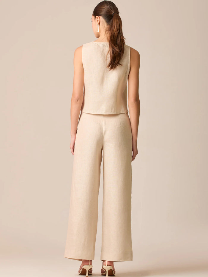 Pantalón de tiro medio con pretina plana, pinzas frontales y corte recto amplio hasta el tobillo, confeccionado en un tejido liviano de textura natural que aporta un look sofisticado y relajado
