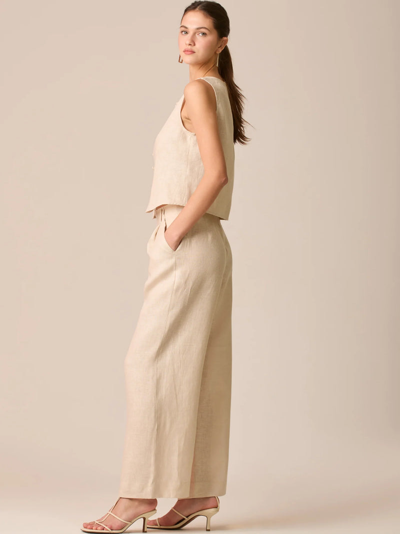 Pantalón de tiro medio con pretina plana, pinzas frontales y corte recto amplio hasta el tobillo, confeccionado en un tejido liviano de textura natural que aporta un look sofisticado y relajado