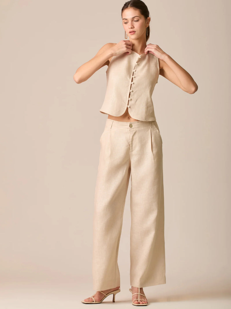 Pantalón de tiro medio con pretina plana, pinzas frontales y corte recto amplio hasta el tobillo, confeccionado en un tejido liviano de textura natural que aporta un look sofisticado y relajado