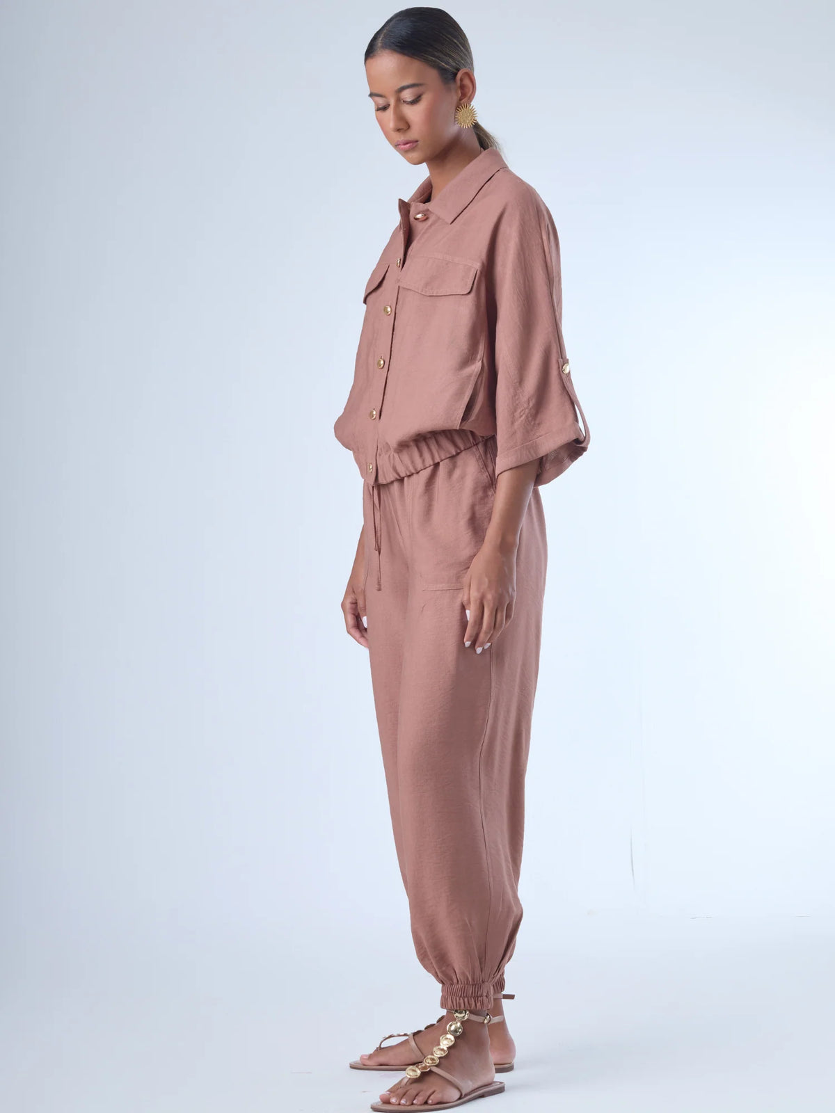 Cómodo y versátil, este pantalón tipo jogger presenta una silueta relajada con ajuste en tobillos y cintura elástica para máximo confort. Los bolsillos frontales tipo parche y la textura suave de la tela lo hacen ideal para looks casuales con un toque elevado. Perfecto para combinar con blusas fluidas o camisas estructuradas, en días de descanso o estilismos urbanos sofisticados.