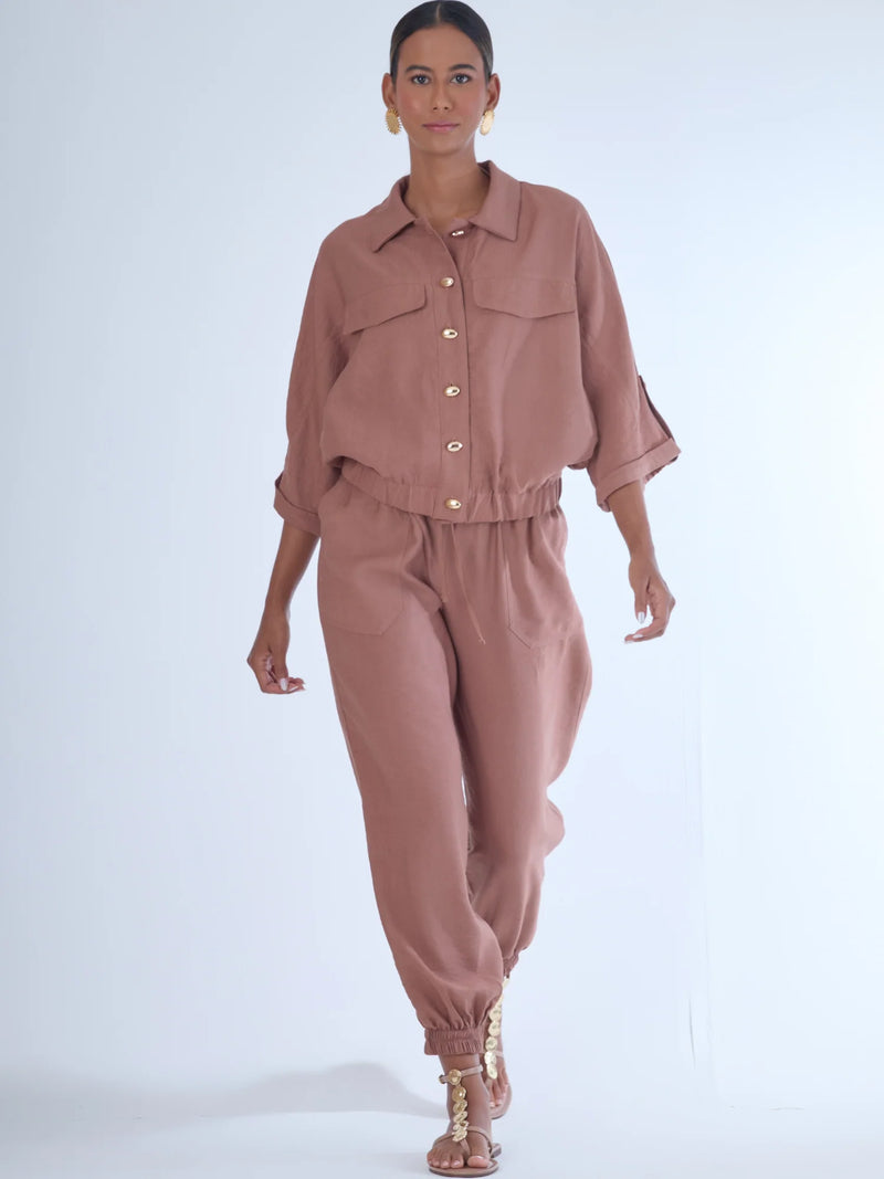 Cómodo y versátil, este pantalón tipo jogger presenta una silueta relajada con ajuste en tobillos y cintura elástica para máximo confort. Los bolsillos frontales tipo parche y la textura suave de la tela lo hacen ideal para looks casuales con un toque elevado. Perfecto para combinar con blusas fluidas o camisas estructuradas, en días de descanso o estilismos urbanos sofisticados.