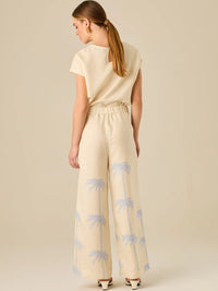 Pantalón de tiro alto con silueta amplia y pierna recta. Confeccionado en tejido liviano y suave, presenta estampado de palmeras a lo largo de ambas piernas que aporta un aire tropical y relajado. Su diseño estructurado combina comodidad y estilo, ideal para días de verano con un toque distintivo.

Detalles:

Color: Sand