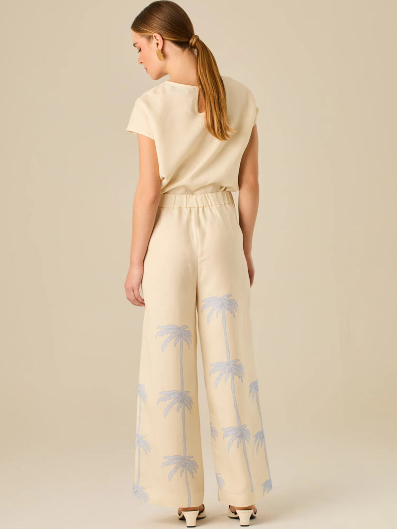 Pantalón de tiro alto con silueta amplia y pierna recta. Confeccionado en tejido liviano y suave, presenta estampado de palmeras a lo largo de ambas piernas que aporta un aire tropical y relajado. Su diseño estructurado combina comodidad y estilo, ideal para días de verano con un toque distintivo.

Detalles:

Color: Sand