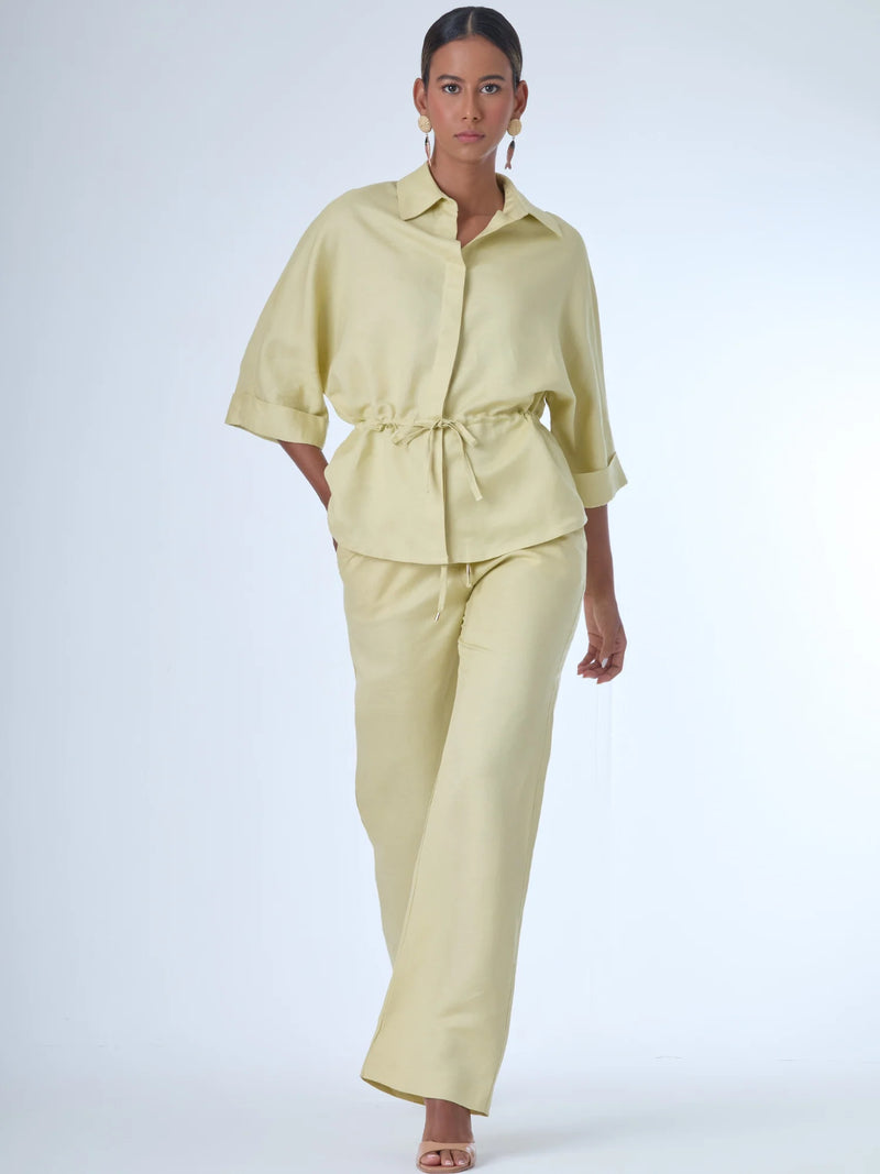Pantalón de corte recto con diseño de pierna ancha, confeccionado en un tejido ligero que aporta caída fluida. De tiro alto, ofrece una silueta alargada y elegante. No lleva bolsillos visibles ni pinzas, lo que refuerza su apariencia limpia y pulida. Ideal para combinar con camisas o blusas sueltas para un estilo sofisticado y relajado.

Detalles:

Color: Ivory

Material: 50% lino 50% Rayon