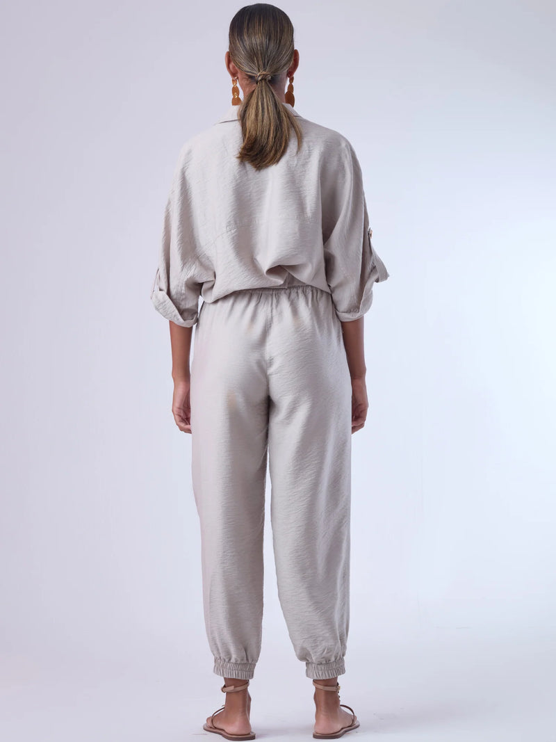 Cómodo y versátil, este pantalón tipo jogger presenta una silueta relajada con ajuste en tobillos y cintura elástica para máximo confort. Los bolsillos frontales tipo parche y la textura suave de la tela lo hacen ideal para looks casuales con un toque elevado. Perfecto para combinar con blusas fluidas o camisas estructuradas, en días de descanso o estilismos urbanos sofisticados.

Detalles:

Color: Cemento