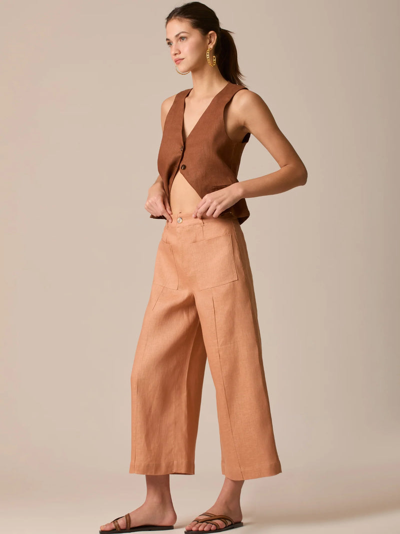 Pantalón de tiro alto con silueta culotte. Pernera amplia y recta con largo cropped al tobillo y dobladillo ancho. Pretina con botón y cierre, bolsillos de parche al frente y pinzas suaves que estilizan la cintura. Versátil y fresco para elevar looks de día o de noche

Detalles:

Color: Peach

Material: 100% Lino