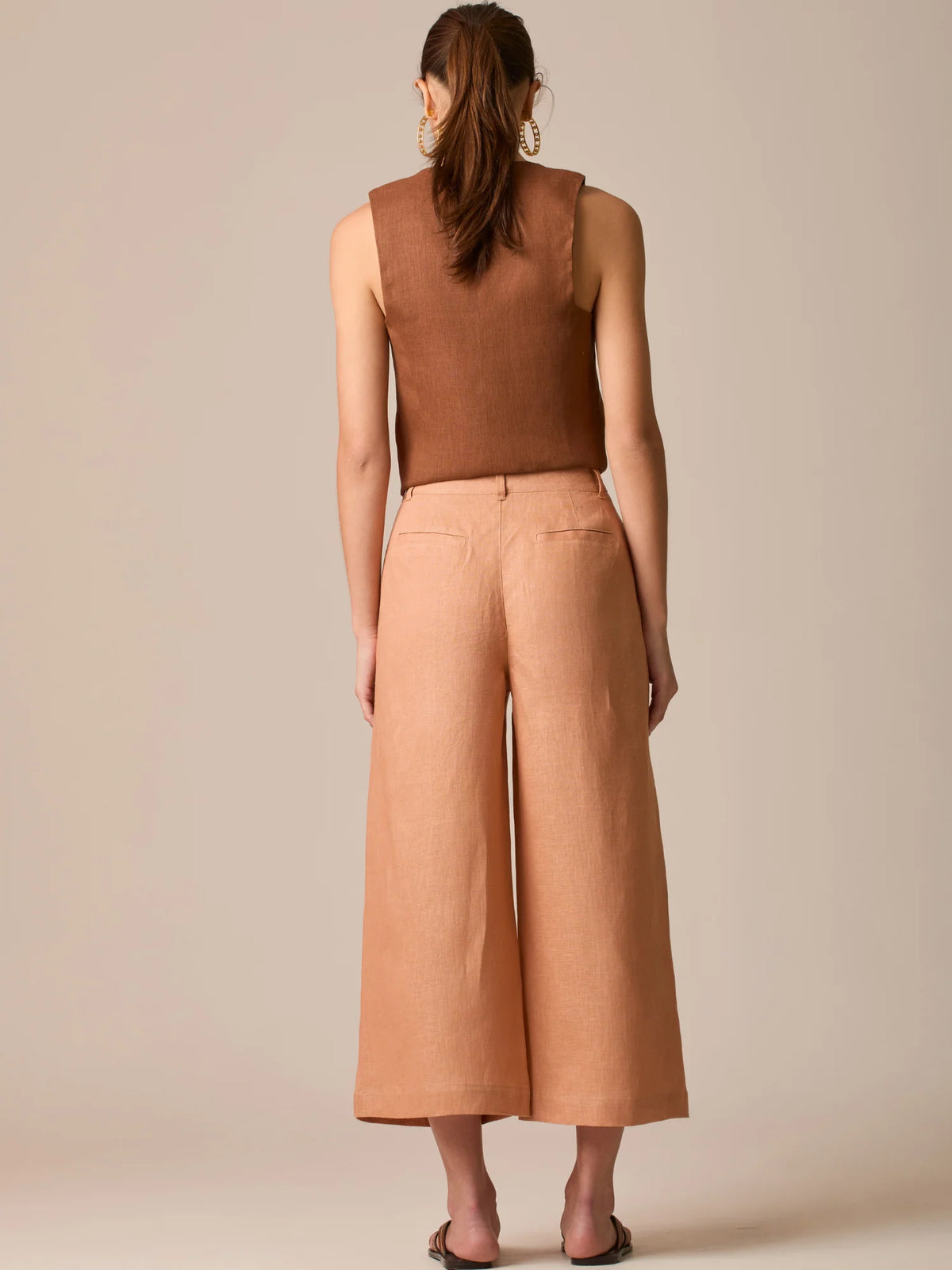 Pantalón de tiro alto con silueta culotte. Pernera amplia y recta con largo cropped al tobillo y dobladillo ancho. Pretina con botón y cierre, bolsillos de parche al frente y pinzas suaves que estilizan la cintura. Versátil y fresco para elevar looks de día o de noche

Detalles:

Color: Peach

Material: 100% Lino