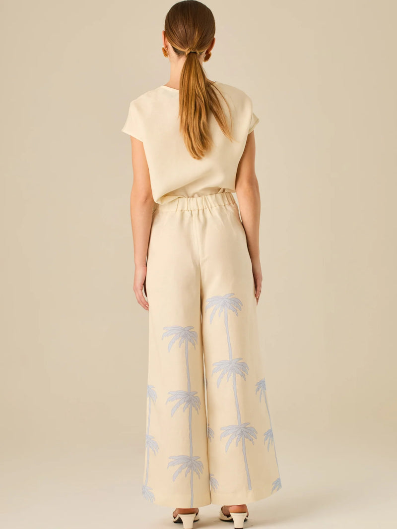 Pantalón de tiro alto con silueta amplia y pierna recta. Confeccionado en tejido liviano y suave, presenta estampado de palmeras a lo largo de ambas piernas que aporta un aire tropical y relajado. Su diseño estructurado combina comodidad y estilo, ideal para días de verano con un toque distintivo.

Detalles:

Color: Sand
