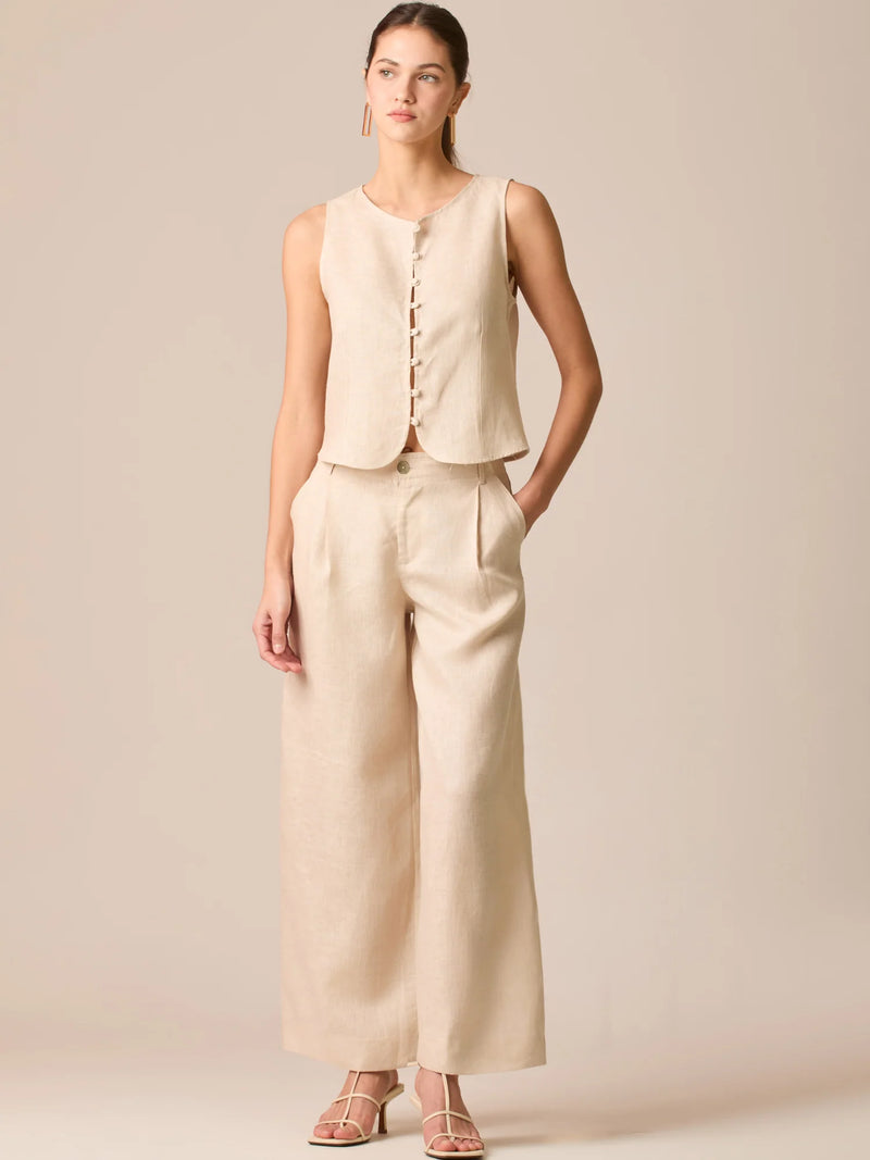 Pantalón de tiro medio con pretina plana, pinzas frontales y corte recto amplio hasta el tobillo, confeccionado en un tejido liviano de textura natural que aporta un look sofisticado y relajado