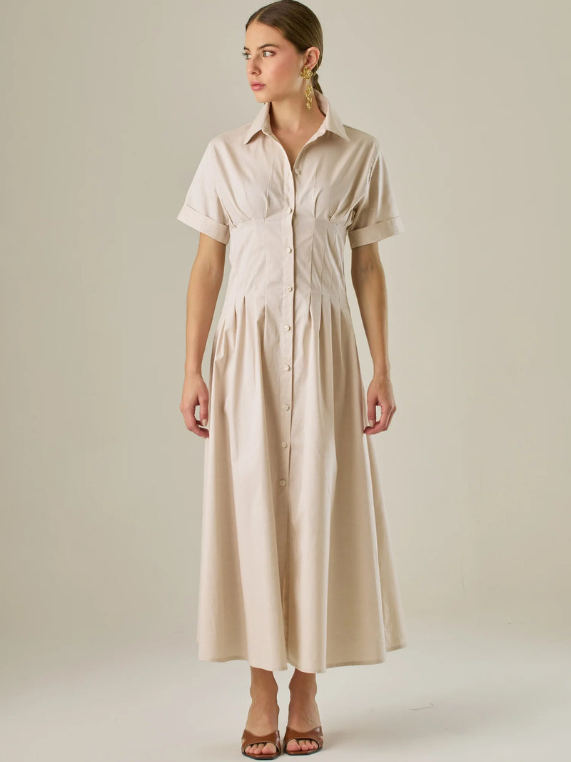 Vestido camisero midi con mangas cortas y falda amplia, ideal para un look elegante y relajado. Su diseño con pinzas en el busto realza la figura con sutileza, mientras que los botones al frente aportan un toque clásico y versátil.

Detalles:

Color: Sand

Material: 97% Algodón 3% Spandex