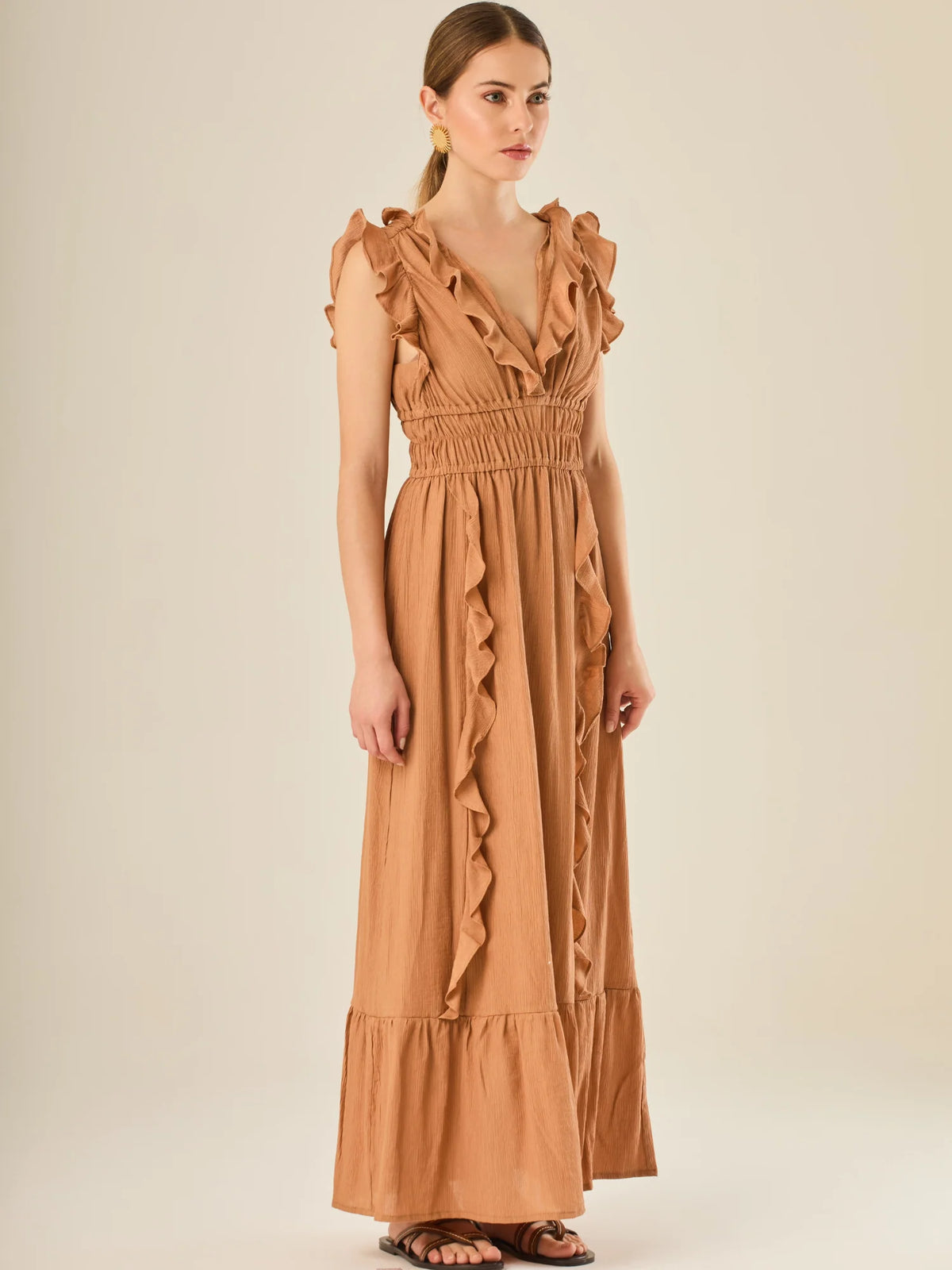 Vestido largo sin mangas con escote en "V" profundo y un diseño con volantes que recorren tanto los tirantes como la parte frontal del busto y la falda. La cintura está fruncida con elástico para dar definición y comodidad, mientras que la falda fluye suavemente con un detalle de volante en el dobladillo, aportando movimiento y un aire femenino al conjunto.

Detalles:

Color: Cafe