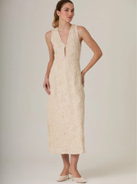 Vestido largo beige con detalles florales y pequeña abertura en el escote para agregar estilo.