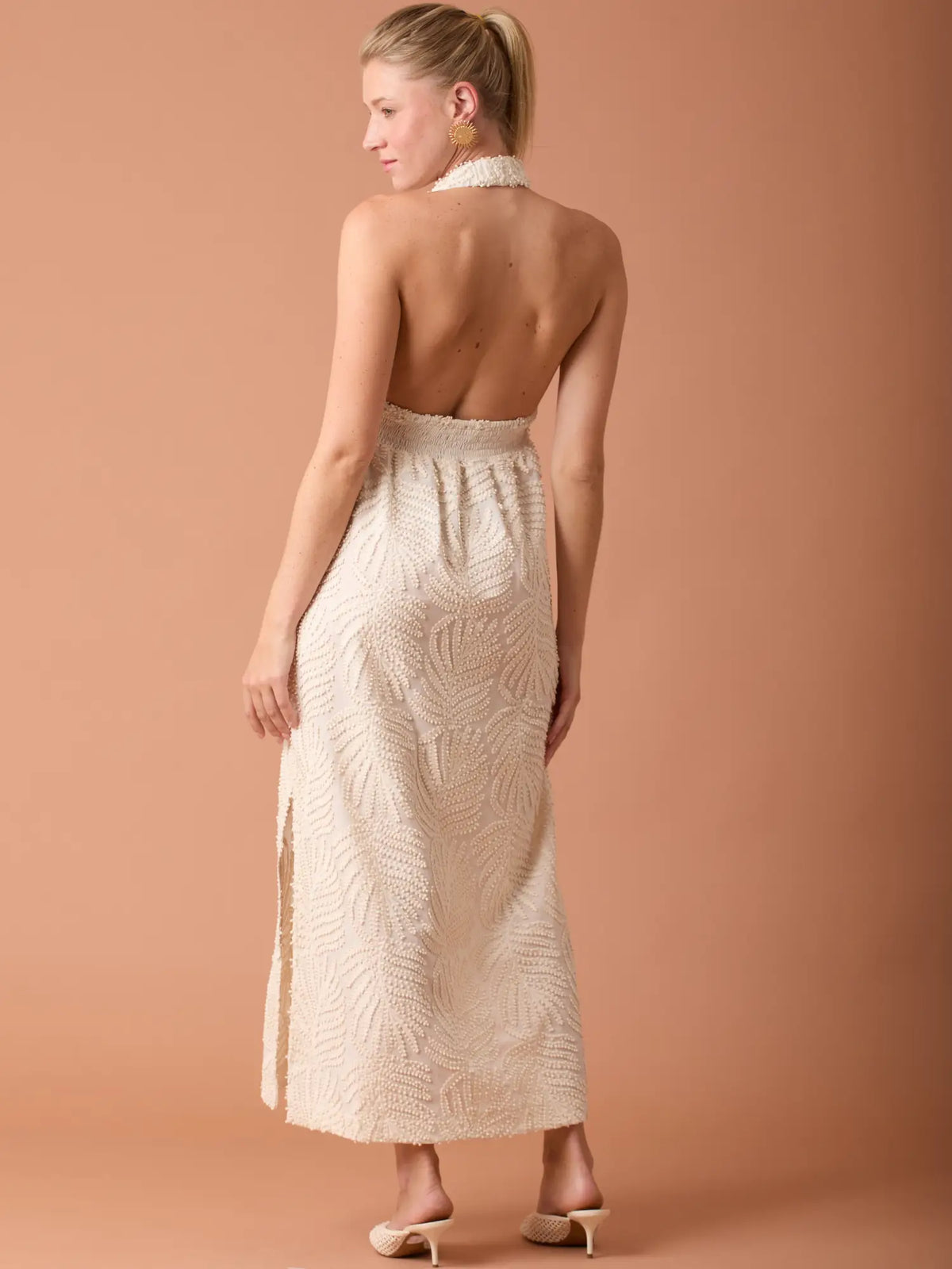 Vestido beige largo para mujer con textura sofisticada y escote halter moderno.