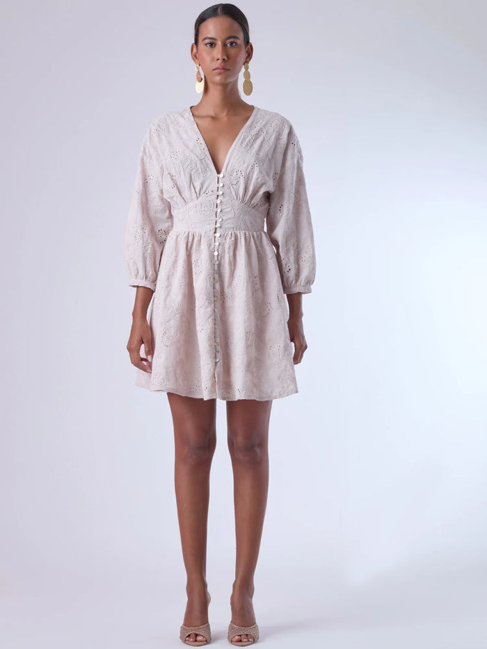 Este vestido de silueta femenina combina un escote en V profundo con una cintura marcada que estiliza la figura. Con mangas 3/4 ligeramente abullonadas y delicados detalles bordados, es una prenda ideal para ocasiones especiales de día o eventos semi formales. Su botonadura frontal añade un toque romántico y clásico que realza su diseño atemporal.